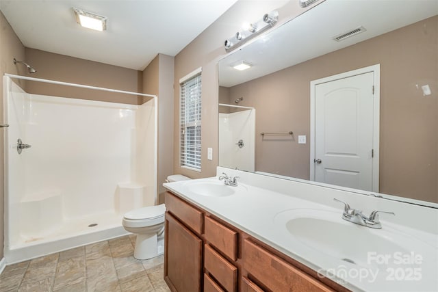 bathroom with vanity, toilet, and a shower