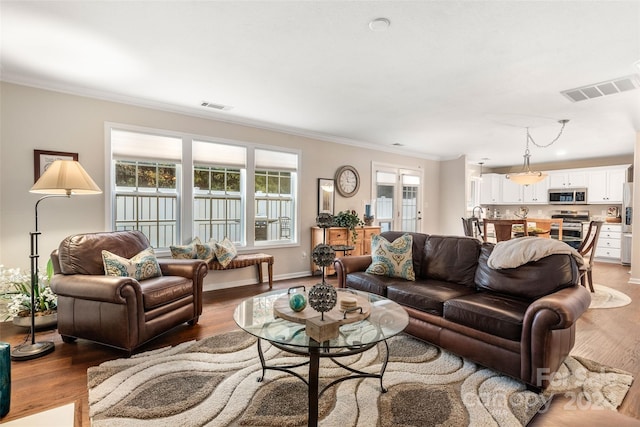 living room featuring hardwood / wood-style flooring and crown molding