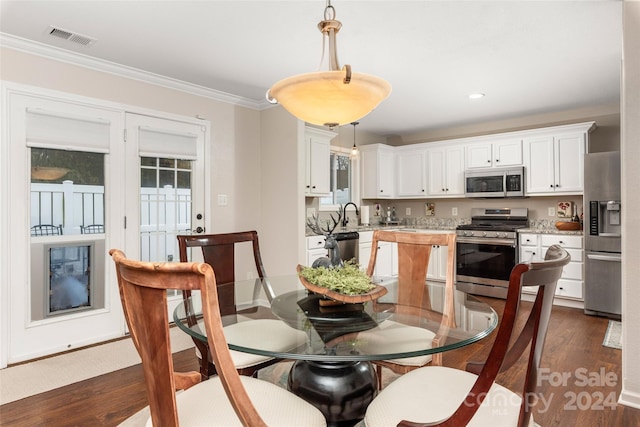 dining area featuring dark hardwood / wood-style floors and crown molding