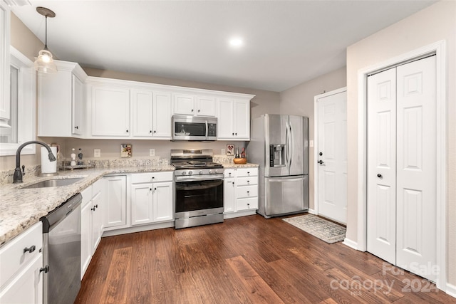 kitchen with sink, dark hardwood / wood-style floors, decorative light fixtures, white cabinets, and appliances with stainless steel finishes