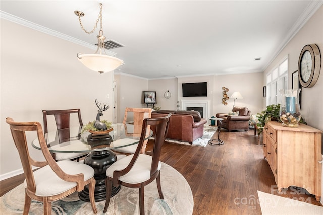 dining room with dark hardwood / wood-style flooring and crown molding