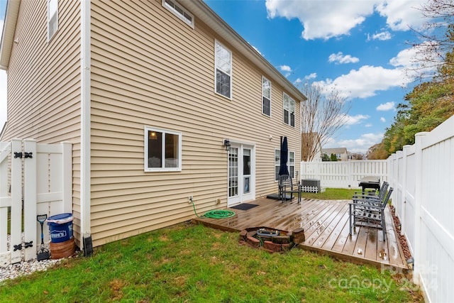 back of property with a deck and a yard