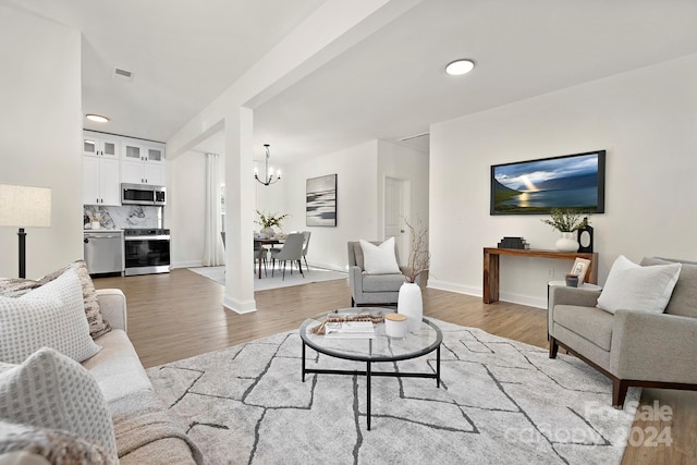 living room featuring an inviting chandelier and hardwood / wood-style flooring