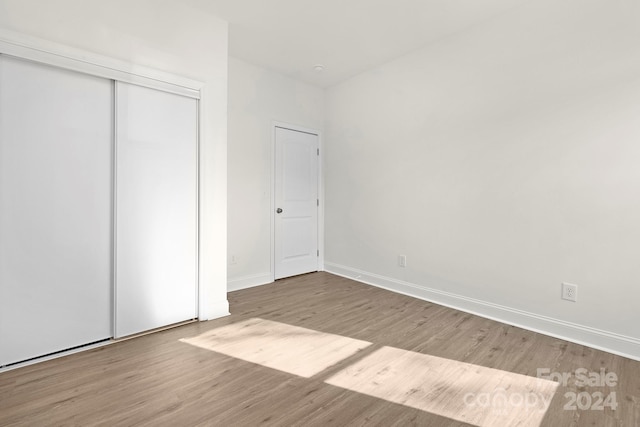 unfurnished bedroom featuring light hardwood / wood-style floors and a closet