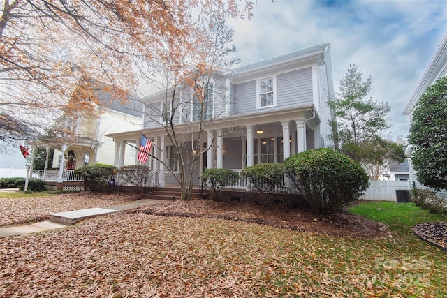 view of front of house with central AC, covered porch, and a front yard