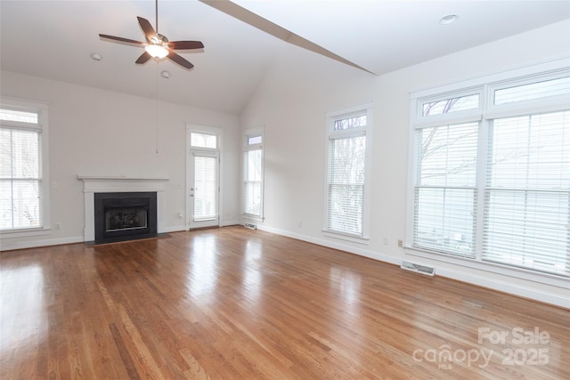 unfurnished living room with ceiling fan, lofted ceiling, and hardwood / wood-style flooring