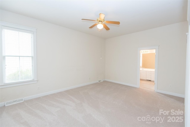 spare room with light carpet, ceiling fan, and a healthy amount of sunlight