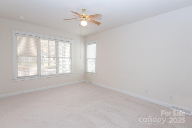 carpeted spare room featuring ceiling fan