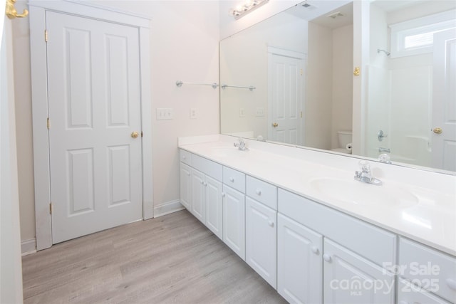 full bathroom with vanity, wood-type flooring, shower / bathtub combination, and toilet