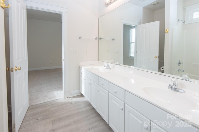 bathroom featuring hardwood / wood-style floors, vanity, and shower / bath combination