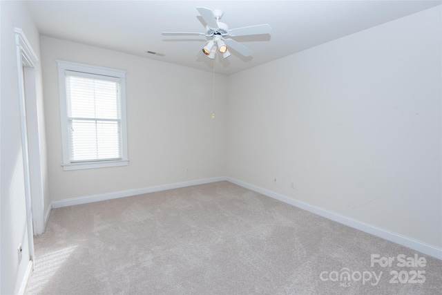 spare room with ceiling fan and light carpet