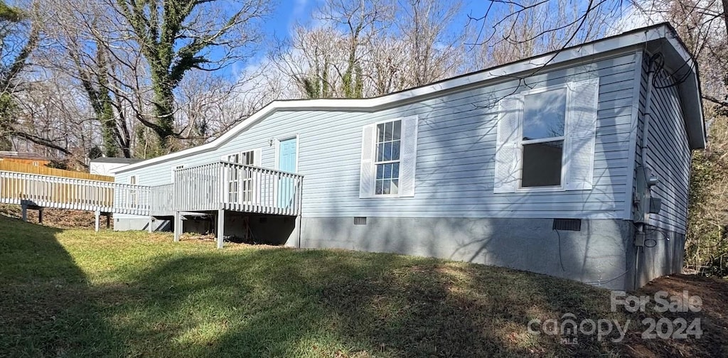 back of property with a lawn and a wooden deck