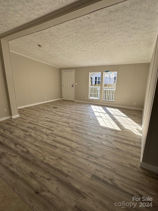 unfurnished living room featuring hardwood / wood-style floors and a textured ceiling