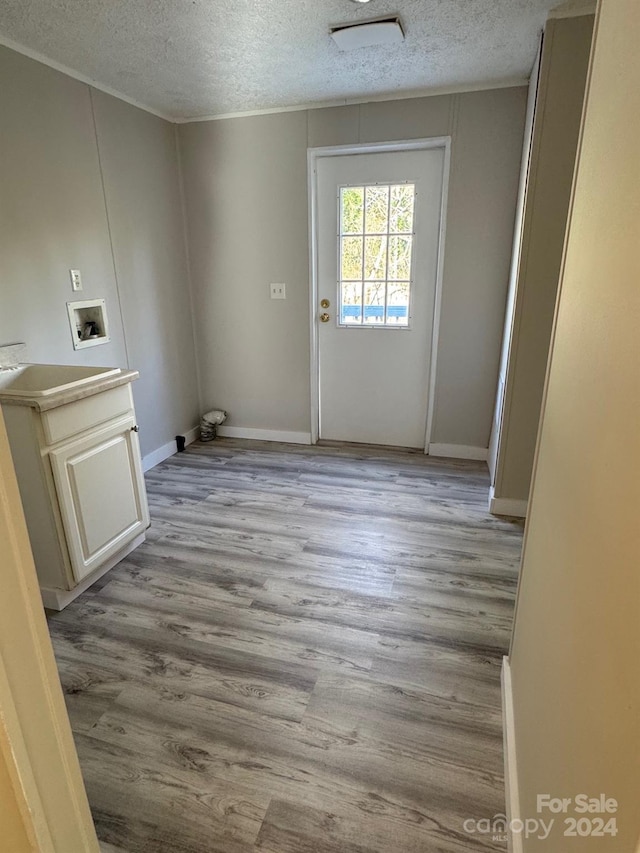 washroom featuring light hardwood / wood-style flooring, washer hookup, a textured ceiling, and sink