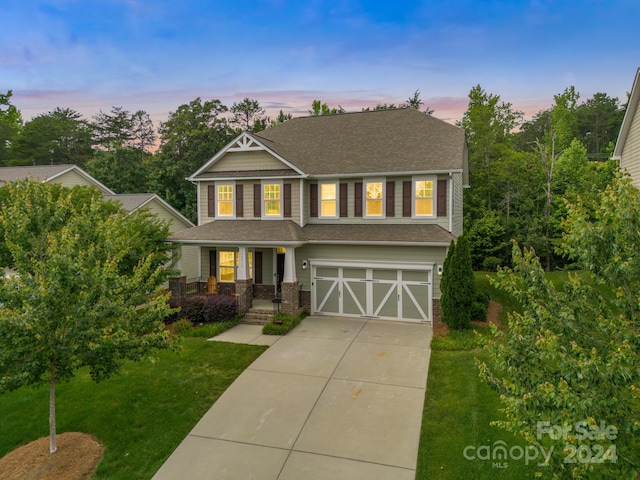 view of front of property featuring a garage and a lawn