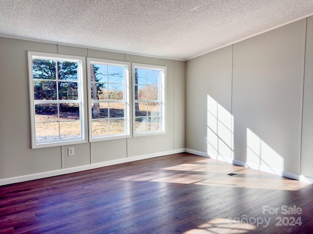 spare room featuring hardwood / wood-style floors and a textured ceiling