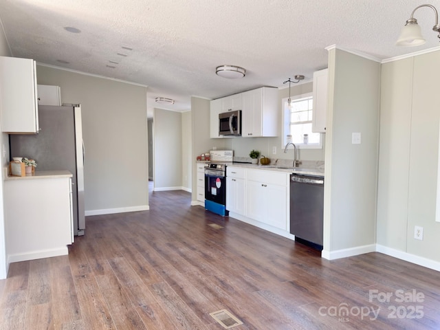 kitchen featuring hanging light fixtures, white cabinetry, appliances with stainless steel finishes, and dark wood-type flooring