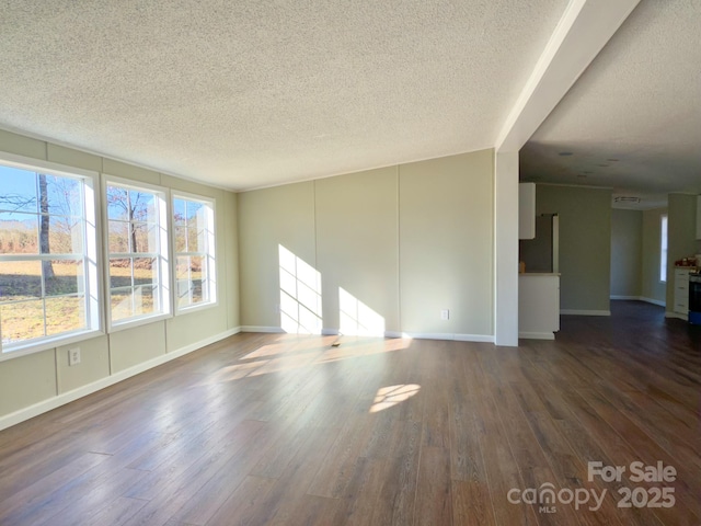 empty room featuring a textured ceiling and dark hardwood / wood-style flooring