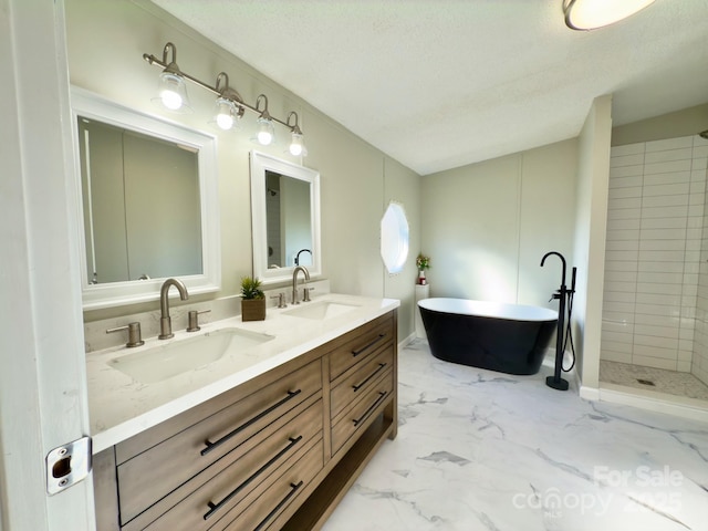 bathroom featuring vanity, separate shower and tub, and a textured ceiling