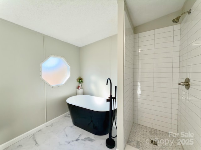 bathroom featuring plus walk in shower and a textured ceiling