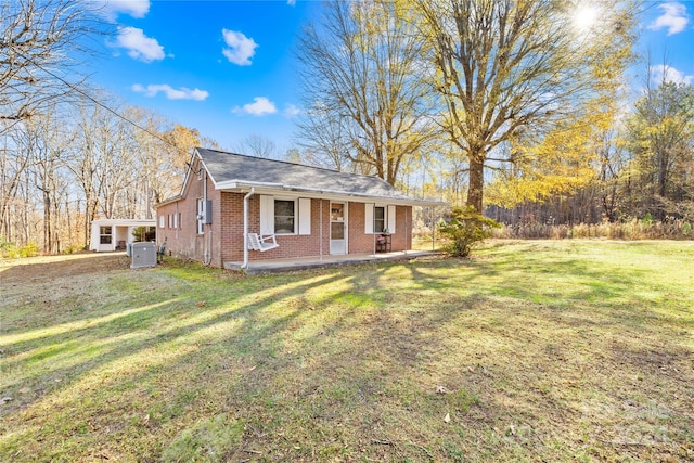 single story home featuring cooling unit, a front lawn, and a porch