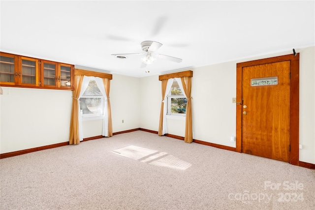 unfurnished room with ceiling fan and light carpet