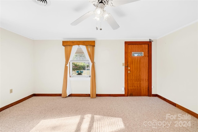 carpeted empty room featuring ceiling fan and ornamental molding