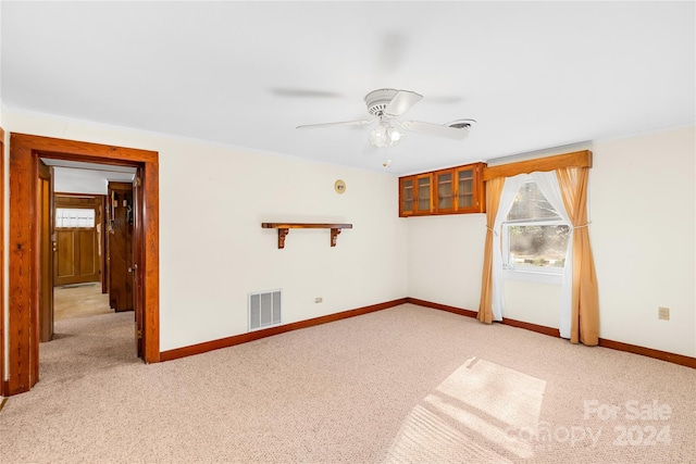 unfurnished room with ceiling fan and light colored carpet