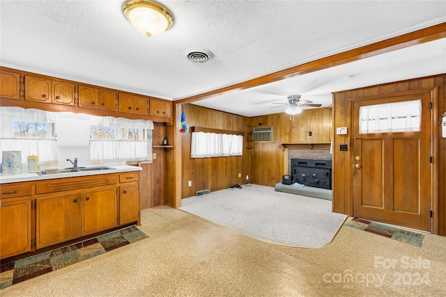 kitchen with wood walls, plenty of natural light, and sink