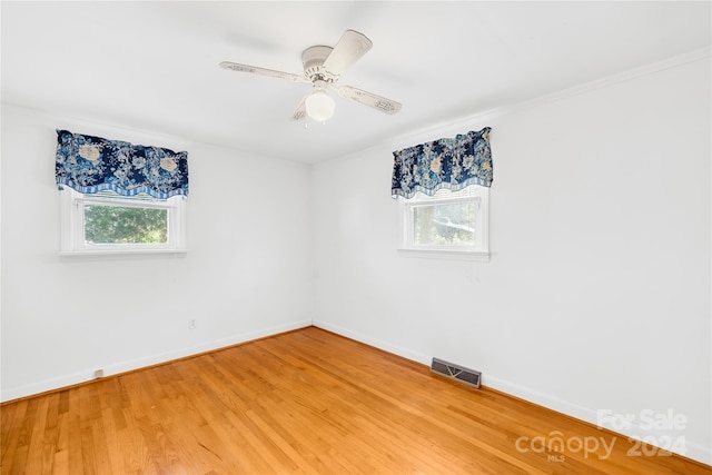 empty room with ceiling fan, crown molding, and hardwood / wood-style flooring