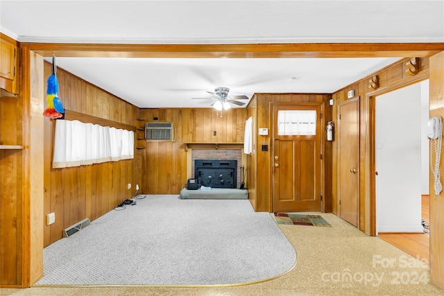 living room featuring ceiling fan, wood walls, light carpet, and a wall unit AC