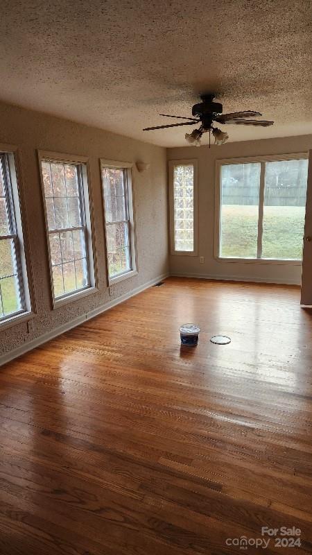 unfurnished room featuring ceiling fan, a textured ceiling, and hardwood / wood-style flooring