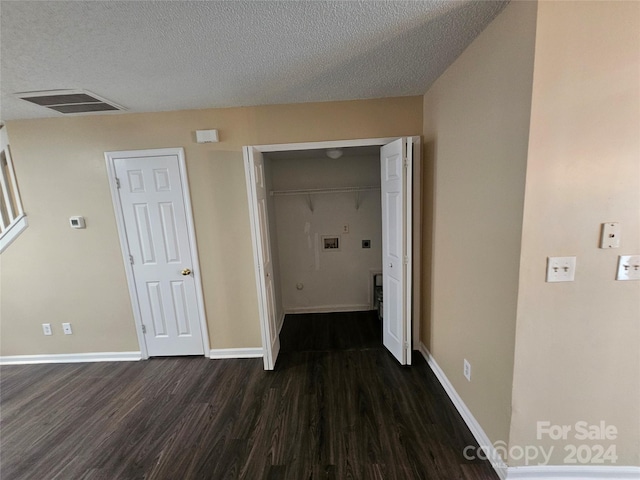 hallway featuring dark hardwood / wood-style floors and a textured ceiling