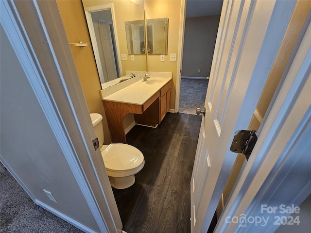 bathroom with vanity, wood-type flooring, and toilet