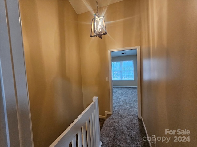 hall with carpet floors and vaulted ceiling