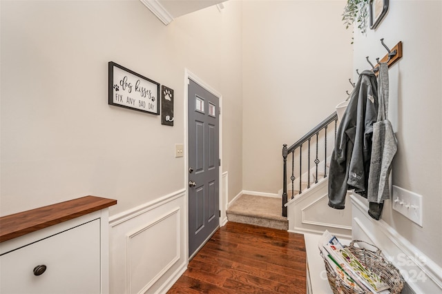 entryway featuring crown molding and dark wood-type flooring