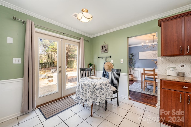 dining room with a chandelier, light tile patterned flooring, ornamental molding, and french doors