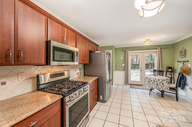 kitchen featuring light stone countertops, french doors, stainless steel appliances, tasteful backsplash, and crown molding