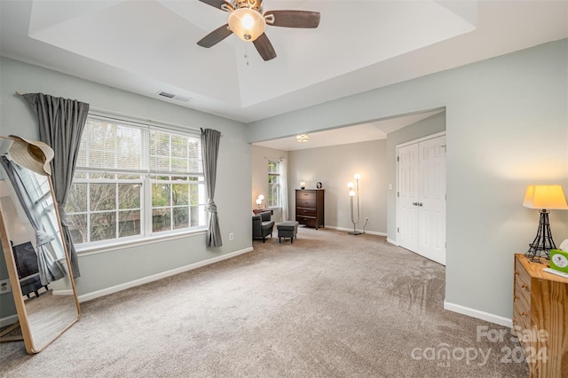 interior space with ceiling fan, a tray ceiling, and a closet