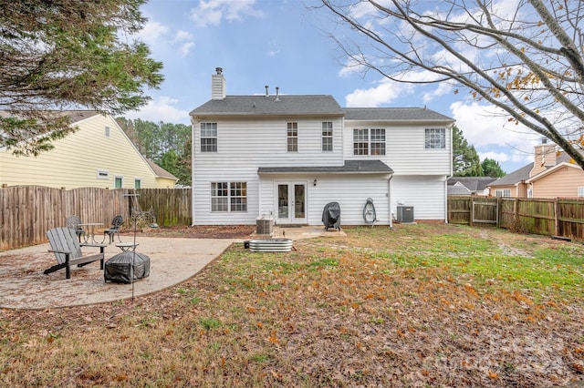 back of property with french doors, an outdoor fire pit, a patio area, and central air condition unit