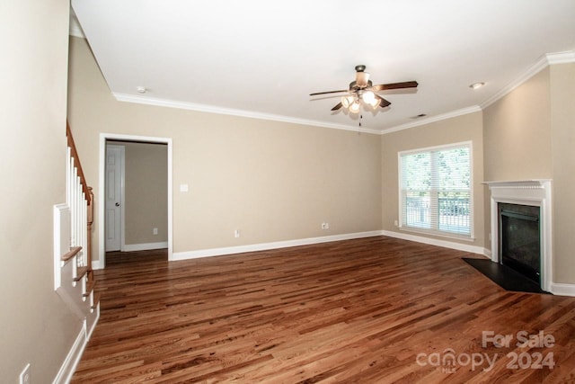 unfurnished living room with ceiling fan, ornamental molding, and dark wood-type flooring