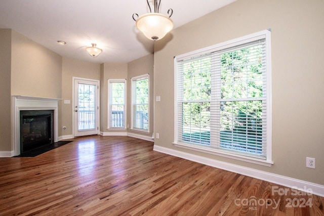 131 Quail Haven Dr, Troutman, NC 28166 - unfurnished living room with wood finished floors and a fireplace with flush hearth
