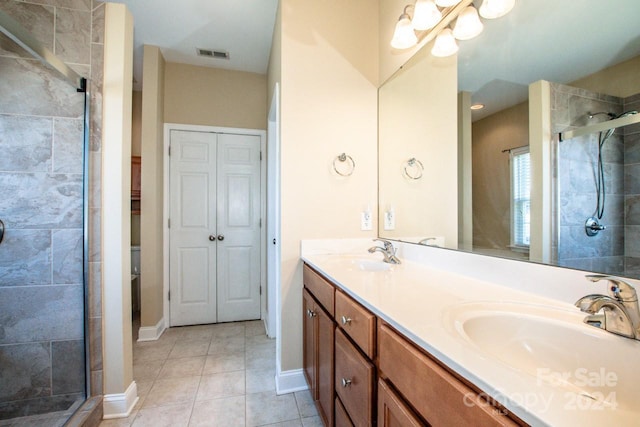 bathroom with tile patterned floors, vanity, and a shower with shower door