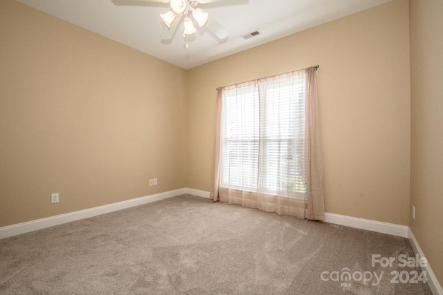 carpeted spare room with ceiling fan