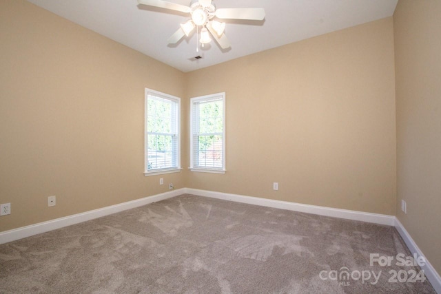 carpeted spare room with ceiling fan