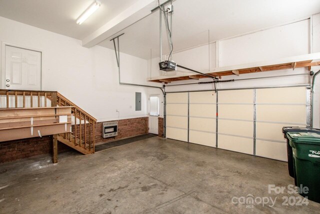 garage with electric panel, a garage door opener, and heating unit