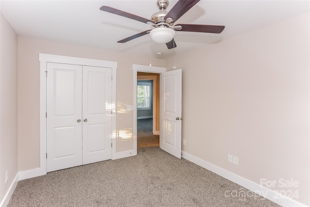 unfurnished bedroom with ceiling fan, a closet, and light carpet