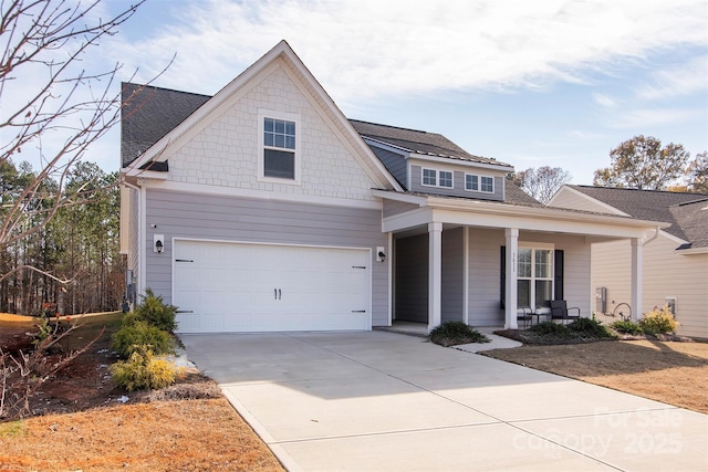 view of front of house featuring driveway, covered porch, and a garage