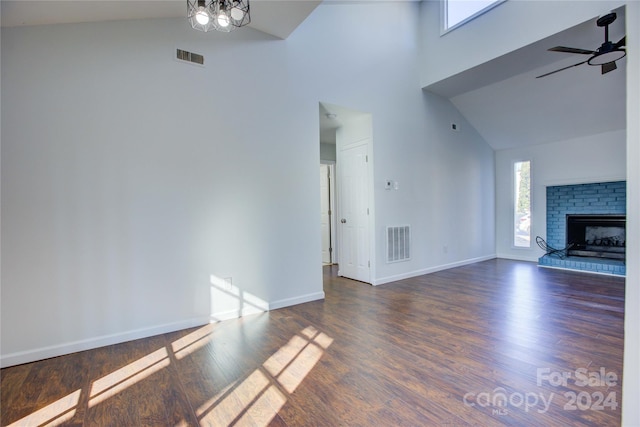 unfurnished living room featuring ceiling fan, high vaulted ceiling, dark hardwood / wood-style floors, and a brick fireplace