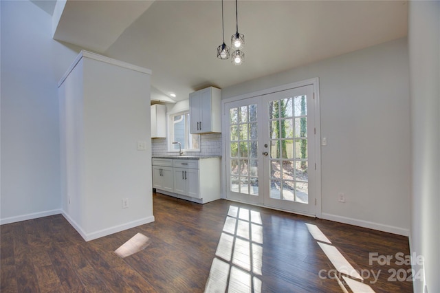 2515 Dion Ave, Charlotte, NC 28212 - kitchen featuring lofted ceiling, white cabinets, backsplash, hanging light fixtures, and dark wood finished floors